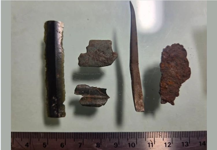 Archaeological metal artifacts with scale ruler